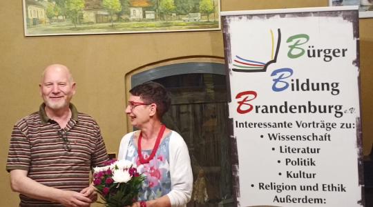 Heiko Krause überreicht Simona Koss nach der Veranstaltung einen Blumenstrauß
